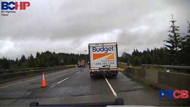 Un camion de location arrêté sur l’autoroute et une zone de construction en arrière-plan