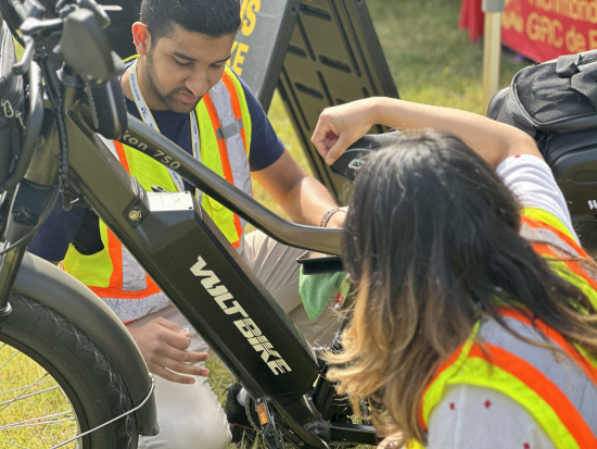 Deux bénévoles procédant à l’inspection d’un vélo électrique.