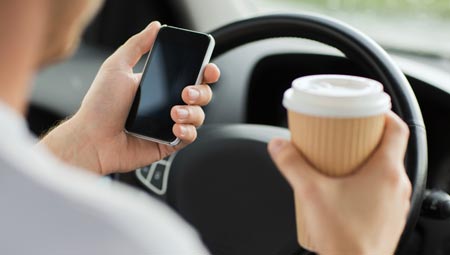 man texting on phone while driving