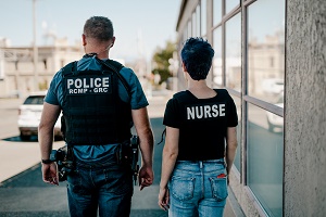 Le gendarme Josh Waltman et l’infirmière Lianne Rear marchent dans la rue.